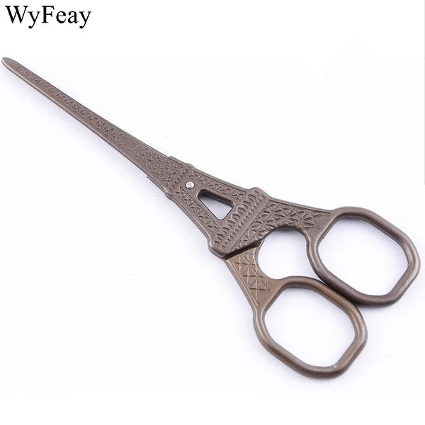 A pair of vintage floral embroidery scissors with dark brown handles and silver accents.