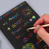 A hand writes 'Happy! Good! Brunch Look' on a black notebook page with colorful scratch art.