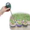 A hand holds a green soil moisture meter with a metal probe, measuring moisture in potted plants.