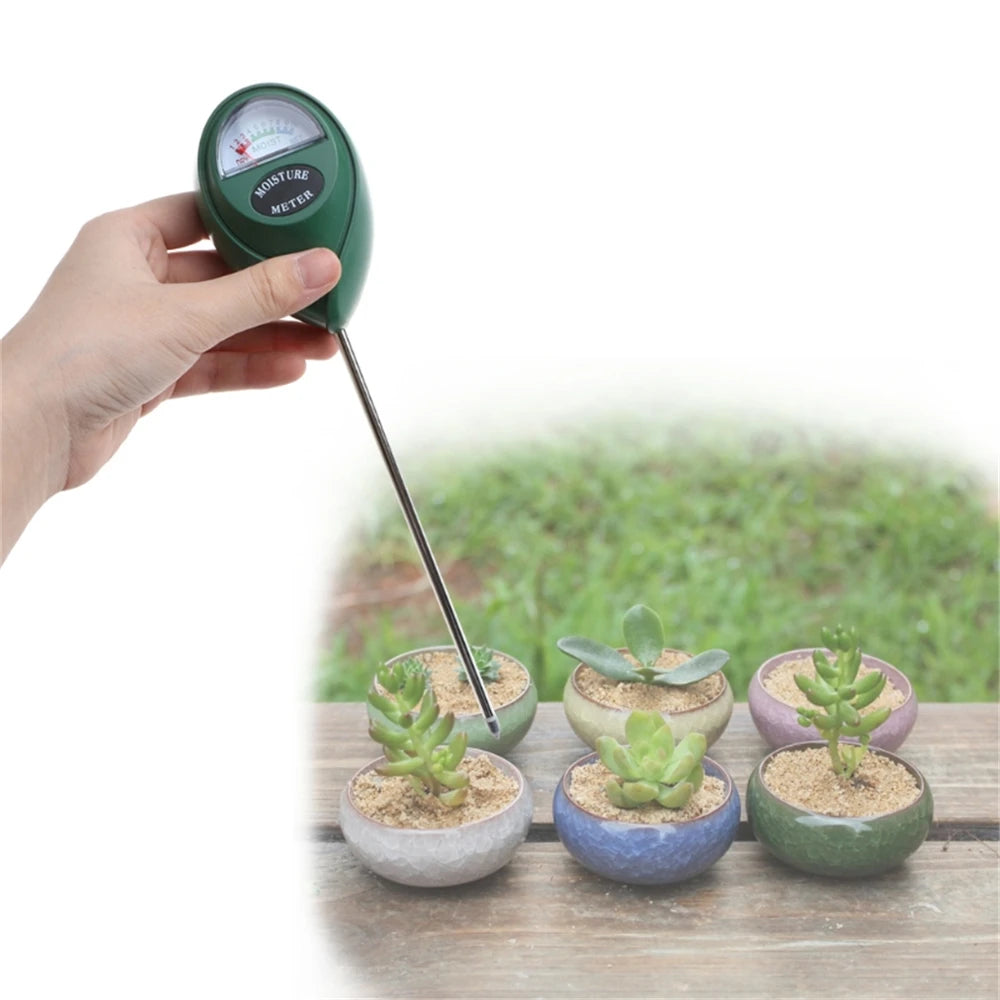 A hand holds a green soil moisture meter with a metal probe, measuring moisture in potted plants.