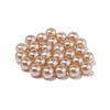 A cluster of round, pale pink imitation pearl beads for jewelry making.