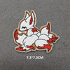 An embroidered patch featuring a white fox head with red accents on a gray background.