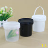 A white storage bucket and a black storage container with lids are displayed on a light brown surface.