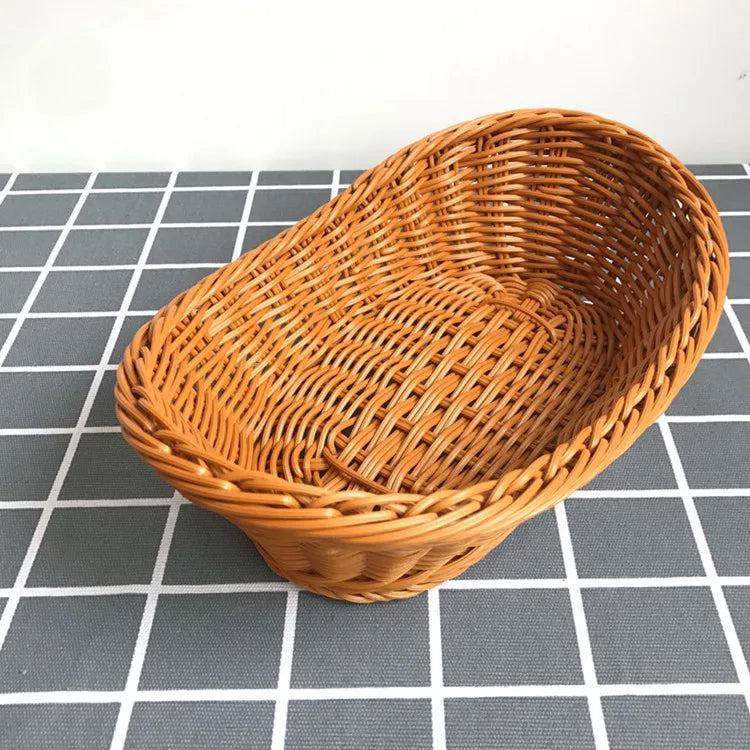 A round, handwoven wicker serving basket in natural brown color resting on a gray and white checkered surface.