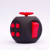 A black fidget cube with red buttons is shown against a white background.