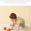 A baby is playing with small orange balls on a light surface.