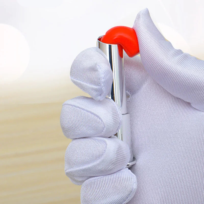 A hand is holding a silver makeup brush with an orange handle, demonstrating the Kids' Pretend Play Makeup Set.