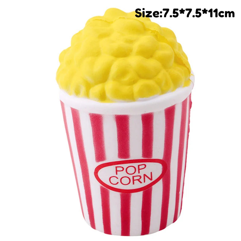 A yellow popcorn squishy toy is shown in a red and white striped paper cup.