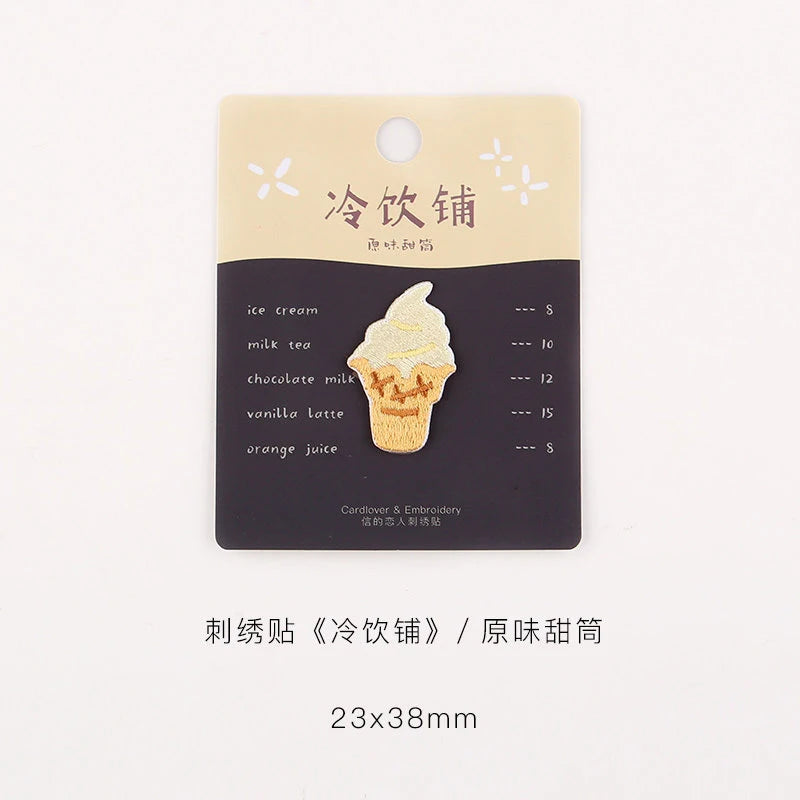 A rectangular beige iron-on patch featuring a dark background and white text listing various iced drink flavors like ice crea