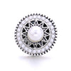 Silver metal snap button with a white pearl center surrounded by small white and black stones