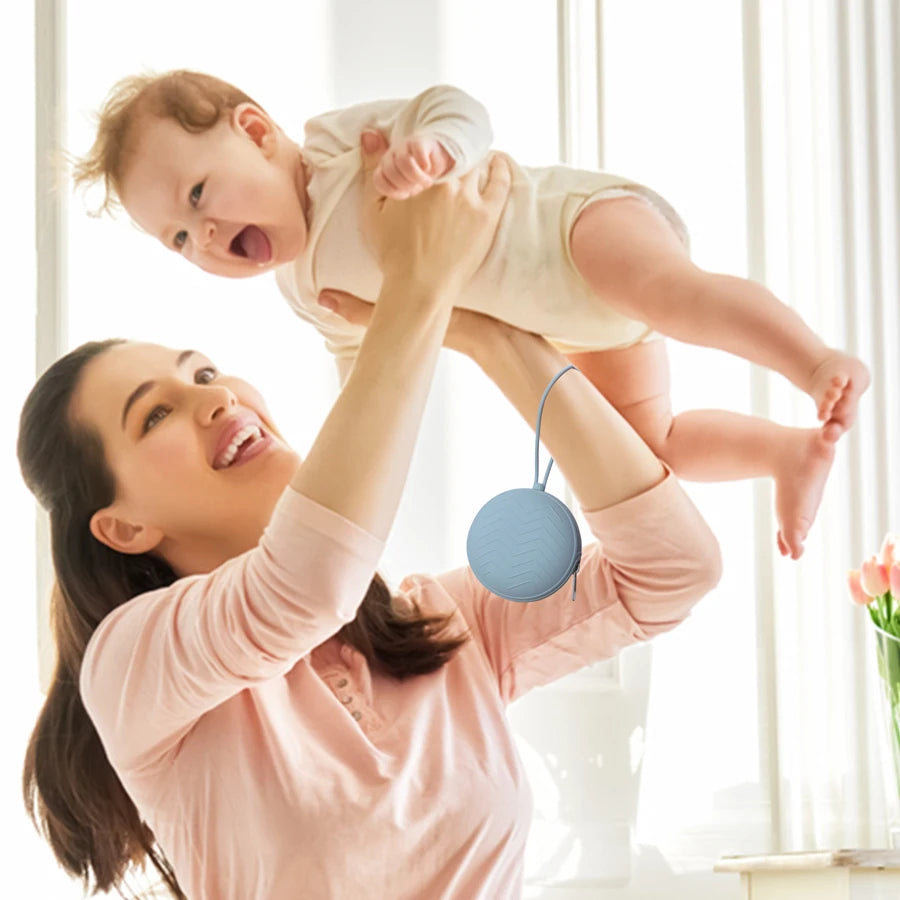 A woman is holding a baby in the air while using a food-grade silicone pacifier case.