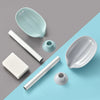 A collection of white and light blue leaf-shaped suction cup soap dishes and tubes on a gray and blue background.