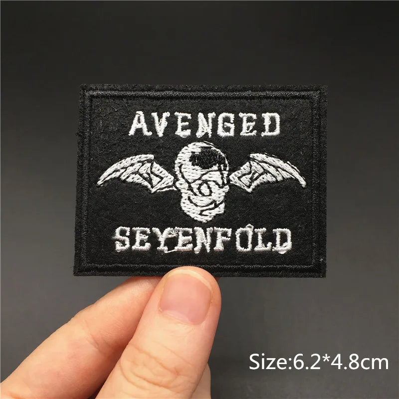 Black embroidered patch with white text AVENGED and SEYENFOLD featuring a skull and wings