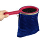 A hand holds a pink and black magic trick prop set with a velvet blue bag.