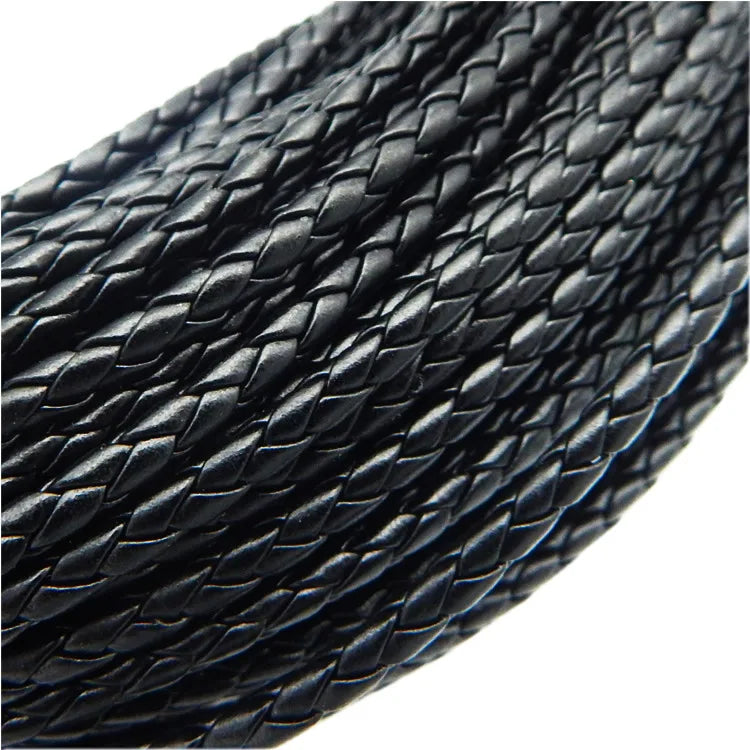A close-up view of a spool of black braided leather cord for jewelry making.