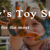 A child holds up their hand painted with colorful, textured paint to show off a toy store gift.