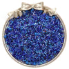 A silver-rimmed dish filled with mixed blue and purple glass seed beads for jewelry making