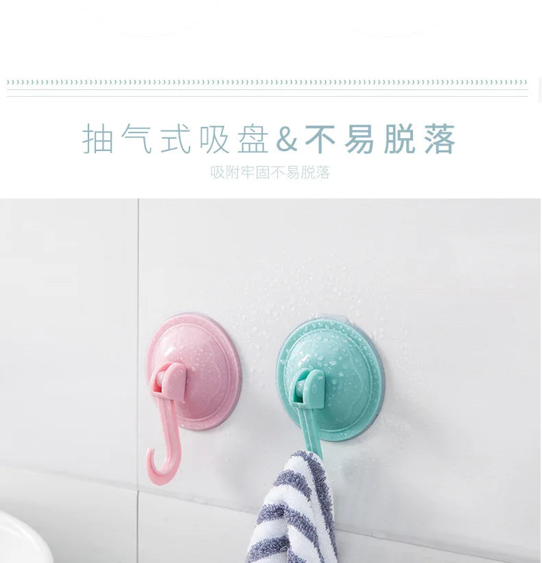 Pink and teal suction cup hooks mounted on a white surface, demonstrating a strong vacuum seal.