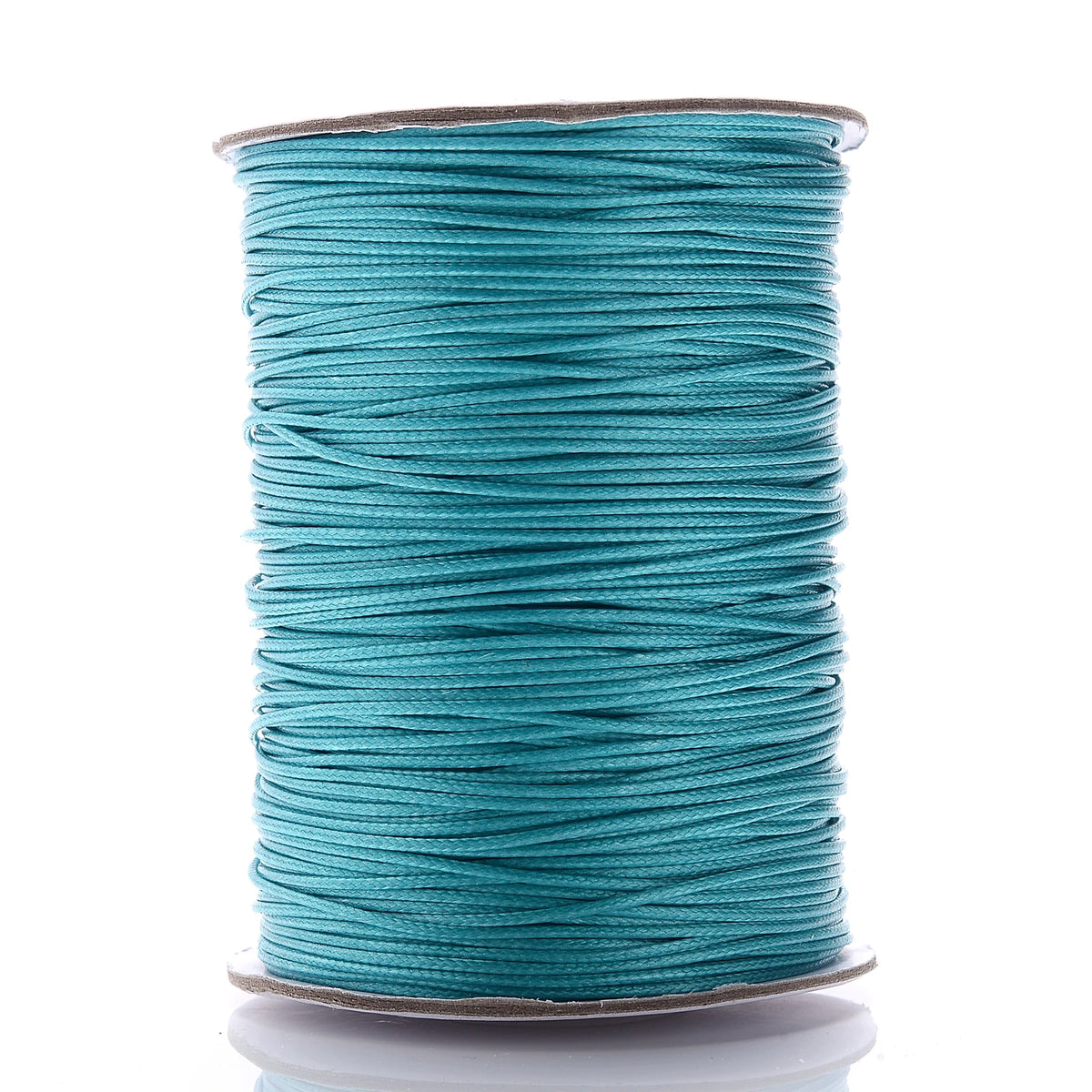 A spool of teal waxed cotton cord used for jewelry making.