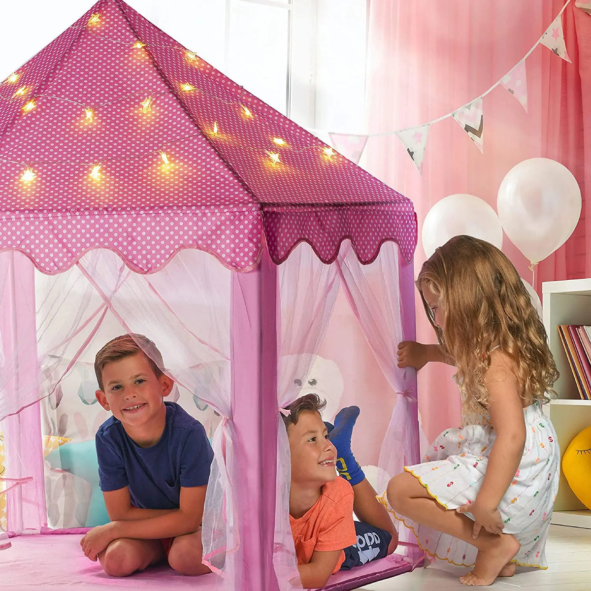 A young girl is playing inside a pink and white polka-dotted foldable princess tipi play tent.