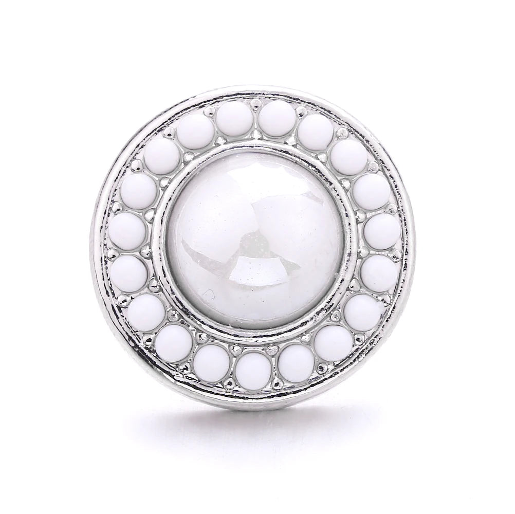 Silver snap button with a central white oval surrounded by a border of smaller white buttons