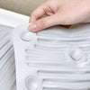 A hand is pressing a silicone washboard with suction cups onto a white plastic surface.
