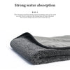 A dark gray microfiber car drying towel is shown folded, highlighting its soft texture.