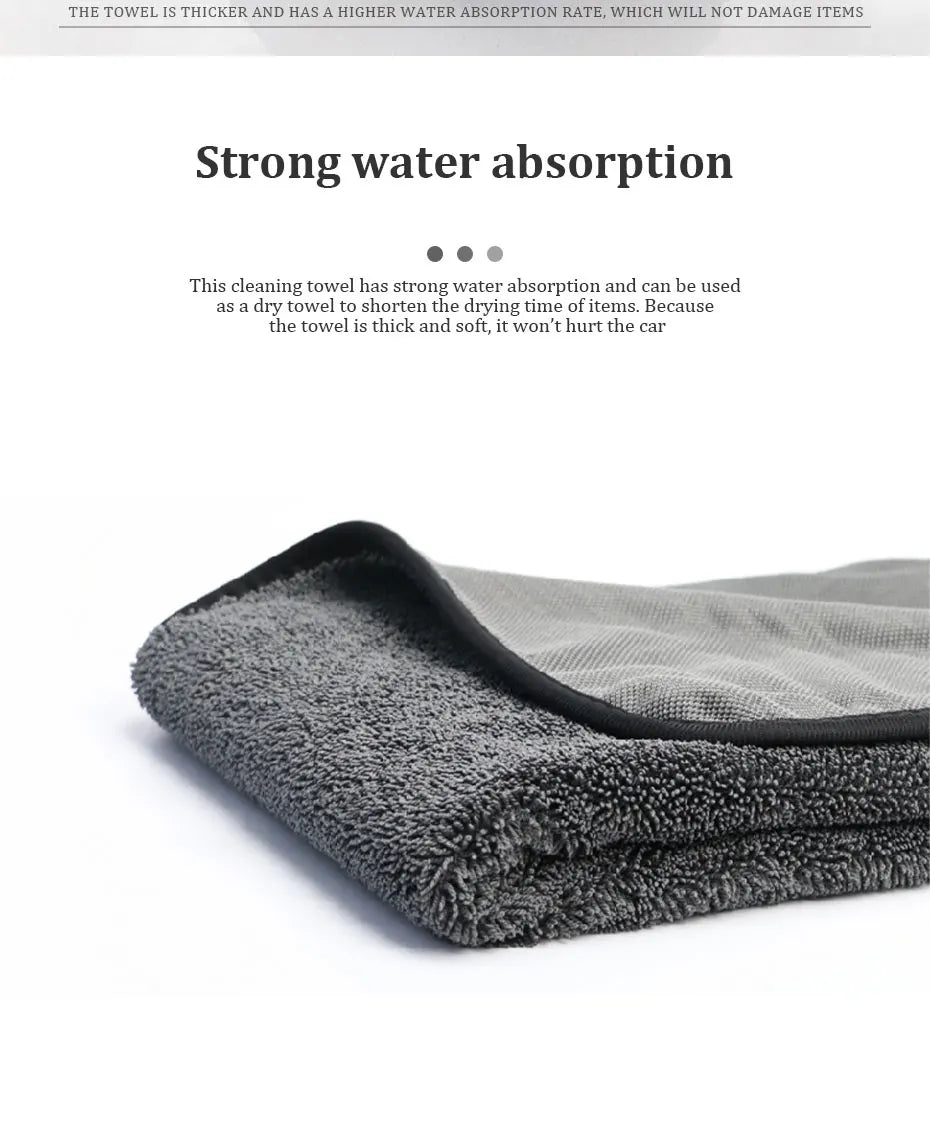 A dark gray microfiber car drying towel is shown folded, highlighting its soft texture.