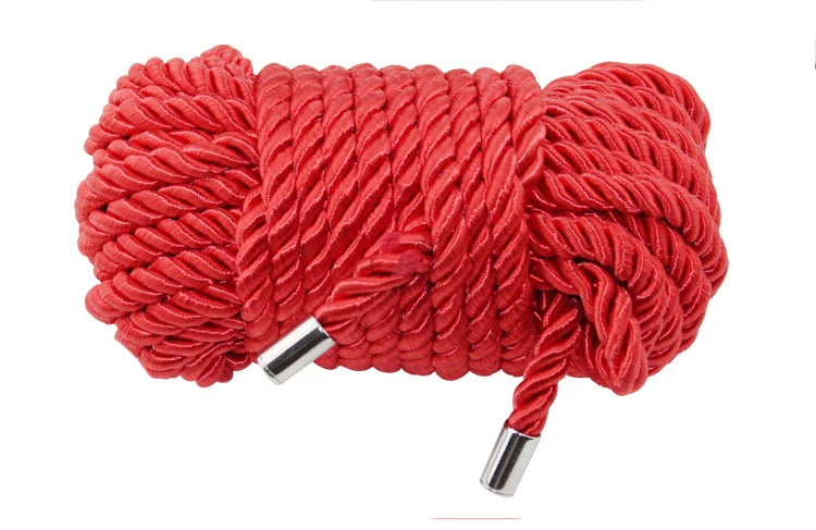 A spool of bright red soft silk bondage rope with silver tips.
