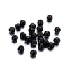 A pile of natural wooden spacer beads in black, arranged on a white background.