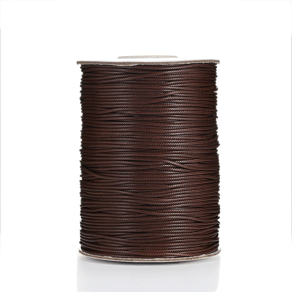 A spool of dark brown waxed cotton cord used for jewelry making
