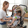 A woman is holding a baby in a soft plush hanging mobile stroller for newborns.