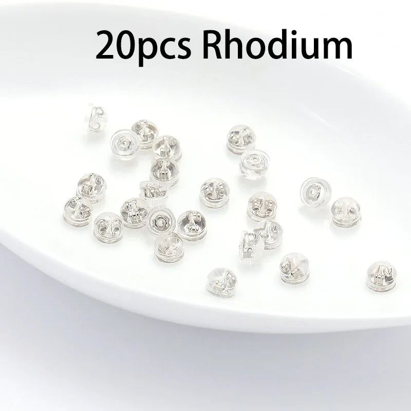 20 pieces of rhodium silicone rubber ear back stoppers with copper rings displayed on a white dish.