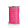 A spool of bright pink waxed cotton cord used for jewelry making.