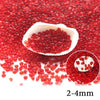 A close-up view of bright red decorative stone pebbles scattered on a white shell.