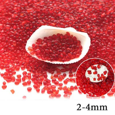 A close-up view of bright red decorative stone pebbles scattered on a white shell.