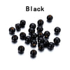 A pile of small, black wooden spacer beads for jewelry and crafts.