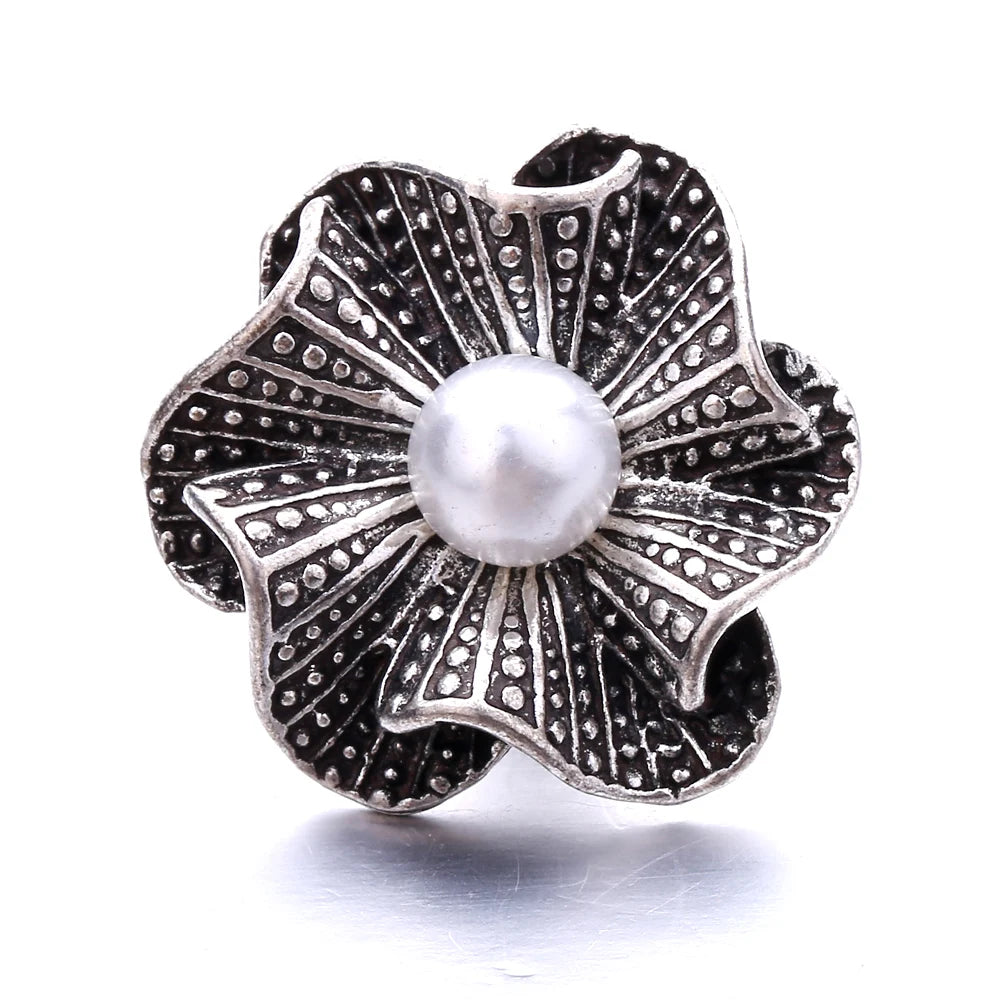 Silver metal snap button shaped like a flower with a pearl center for jewelry making