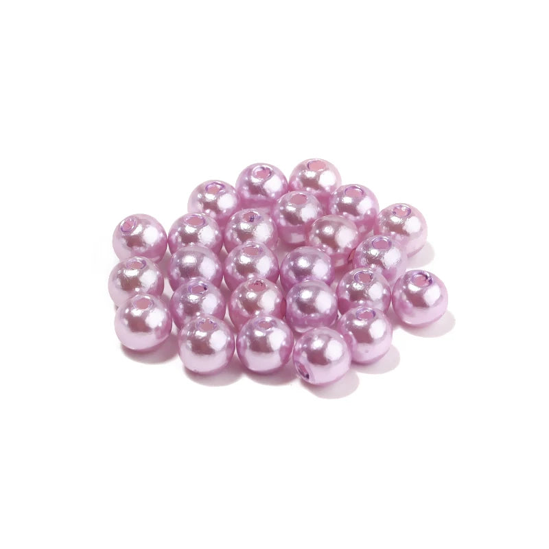 A pile of round pink imitation pearl beads for jewelry making