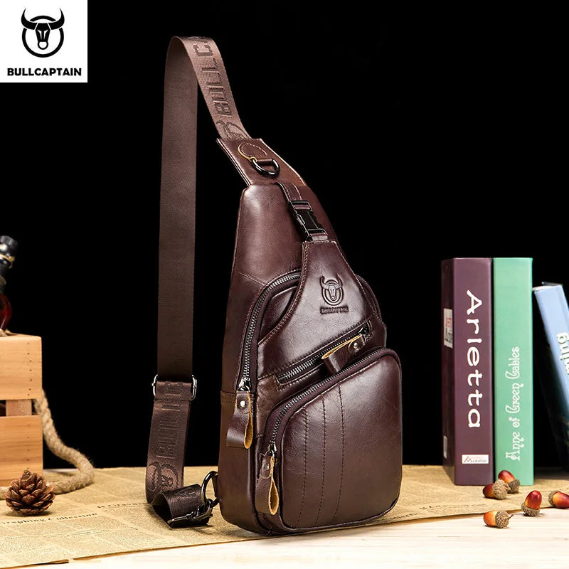 A brown genuine leather chest bag with a strap and zipper is displayed on a wooden surface.