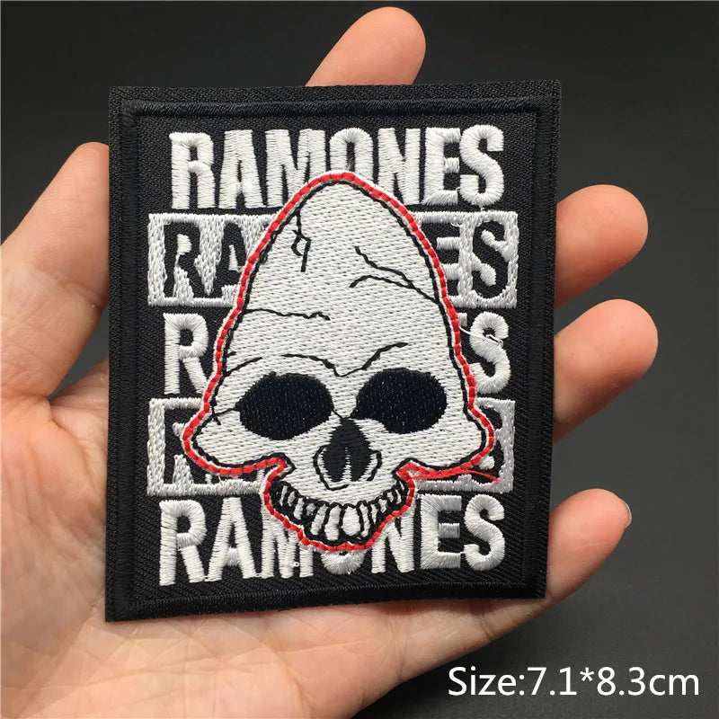 Black embroidered patch featuring the text RAMONES surrounding a white skull design