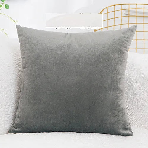 A solid gray velvet decorative cushion cover resting on a white surface.