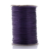 A spool of purple waxed cotton cord used for jewelry making