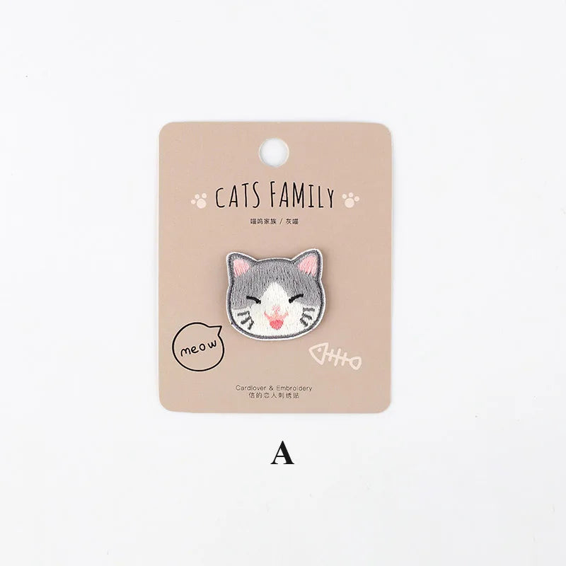 A light brown iron-on patch featuring an embroidered gray and white cat face.