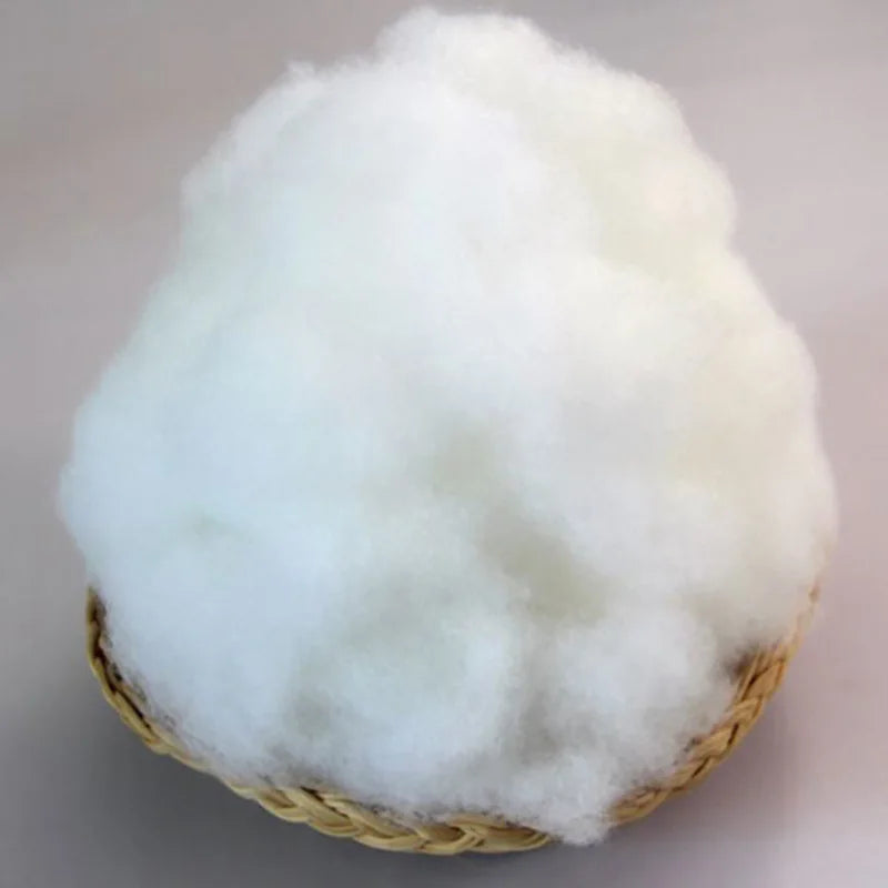 A fluffy white ball of soft polyester pearl cotton stuffing for pillows and DIY crafts.