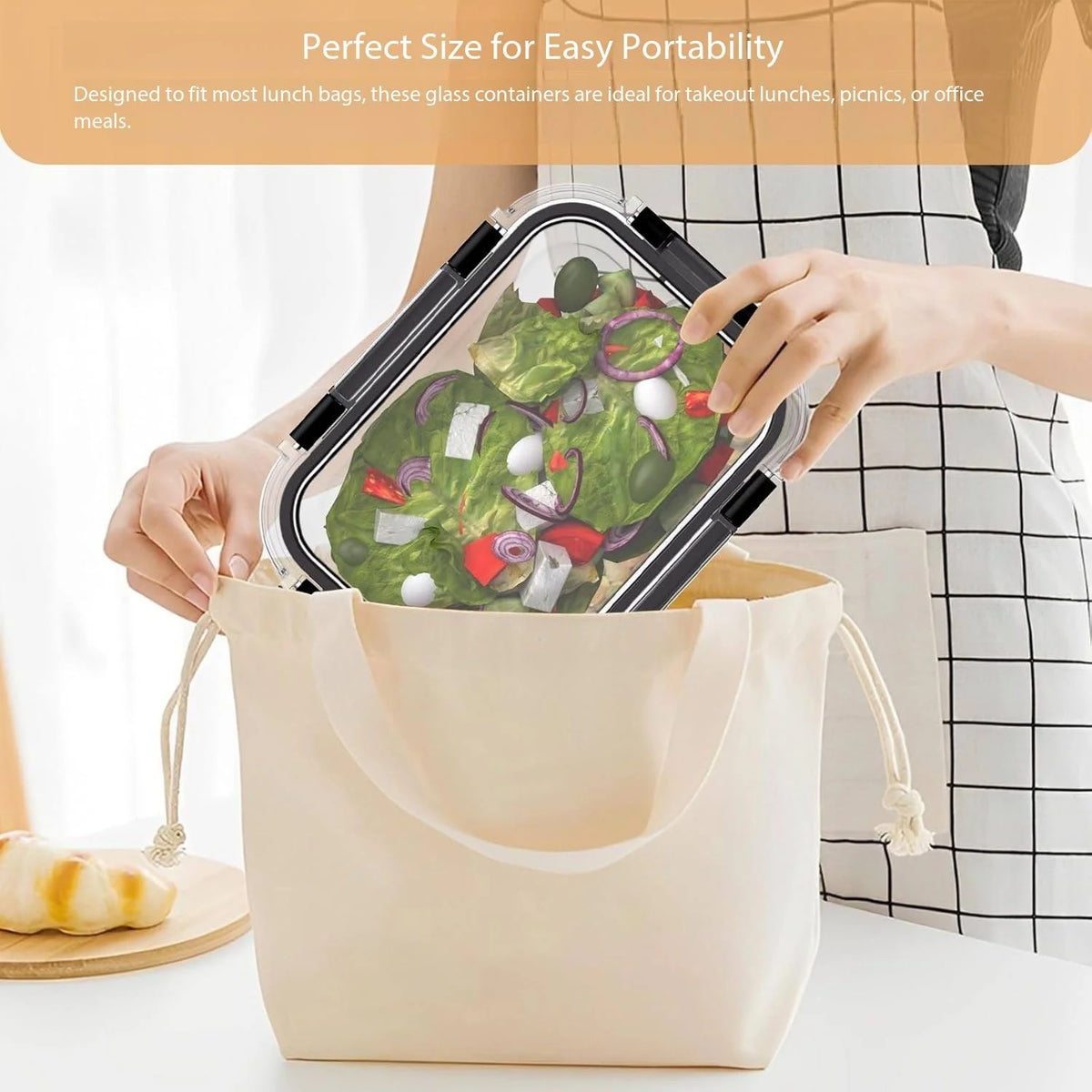 Une main tient un récipient en verre transparent rempli d'une salade, prêt à être transporté.