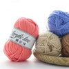 A collection of soft acrylic worsted yarn balls in pink, blue, and beige colors.
