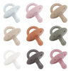 A collection of silicone baby pacifiers or soothers in various pastel colors including white, pink, beige, and gray.