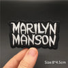Black embroidered patch with white text MARILYN MANSON on a finger