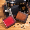 A close-up of a first layer of cowhide leather used in crafting, next to a red and brown genuine leather wallet.